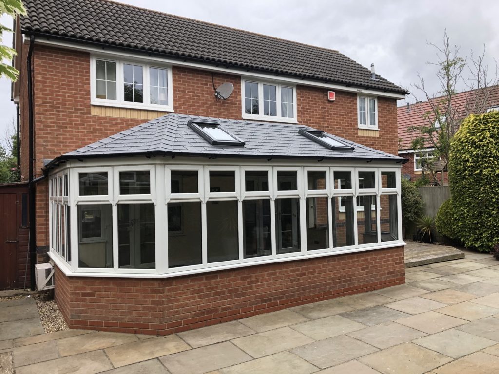 a doubled hipped victorian conservatory with a tiled roof from Nu-Look Conservatory Roof Solutions